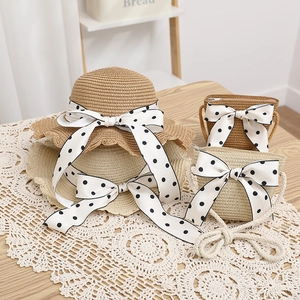 Detail of straw hat and bag sets with polka dot bows on a lace tablecloth