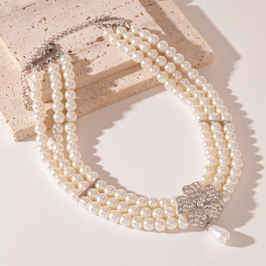 Close-up of multi-layer pearl necklace with rhinestone flower and teardrop pendant
