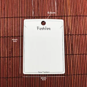 Macro view of white PVC jewelry display card with hanging holes and Fashion text engraving