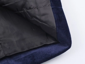 Detailed close-up of dark blue velvet fabric and black twill lining on suit blazer