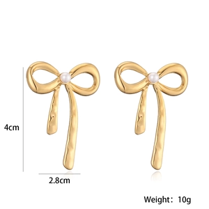 Detailed view of gold bow earrings with white pearl including 4cm by 2.8cm dimensions