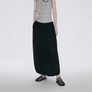 Minimalist black irregular pleated maxi skirt with a Zen-inspired lantern silhouette