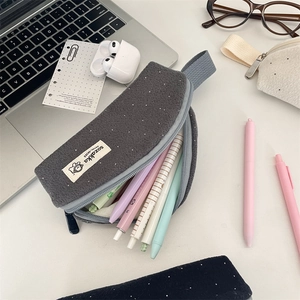 Macro detail of high-capacity dark gray felt pencil case with white polka dot pattern