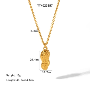 Macro detail of golden peanut pendant with texture and dimensions on cable chain