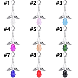 Macro display of nine colorful crystal teardrop angel wing pendants with SKU labels