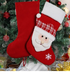 Detail of red velvet and knitted Christmas stockings with Santa embroidery on tree