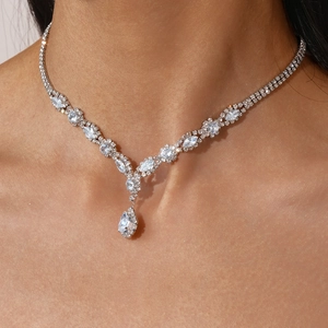 Detailed view of luxury silver V-shaped necklace with teardrop zircon on neck model