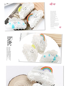 Detailed view of cloud-shaped pearlescent hair claws with rainbow and cute expression motifs
