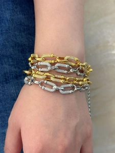 Detalle de pulseras de cadena con eslabones en U en oro y plata con circonitas brillantes