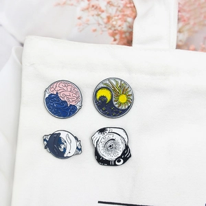 Artistic Yin Yang enamel pin set featuring brain, sun moon, and whales on canvas bag