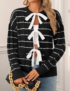Close-up of black and white striped knit cardigan with three white ribbon bow ties