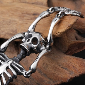 Macro shot of vintage skeleton skull link bracelet on a textured dark wood background