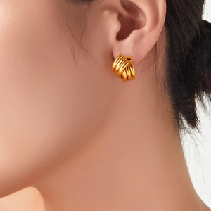 Orecchini geometrici dorati minimalisti con design a spirale intrecciata indossati