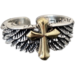 Close-up of vintage silver angel wings and gold cross on a gothic rocker open ring