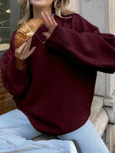 Detailansicht des weinroten Langarmstrickpullovers mit Rippbündchen und Rundhalsausschnitt