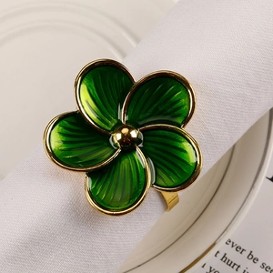 Macro detail of green enamel five-petal flower napkin ring with gold plated edges