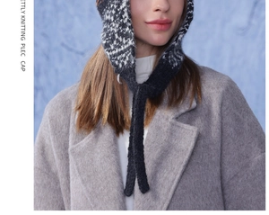 Detail of black and white knitted earflap hat showing intricate jacquard texture