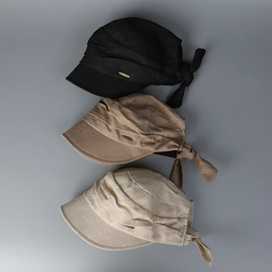Detailed view of linen sun hats with bow decoration and gold logo in three colors