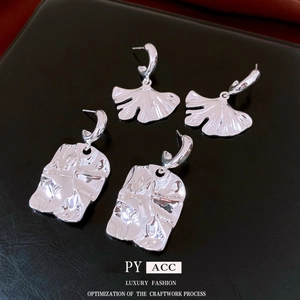 Minimalist silver ginkgo leaf and rectangular textured earrings on black leather