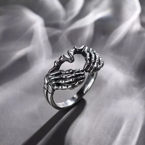 Macro detail of gothic skull hand heart ring with vintage silver oxidized finish