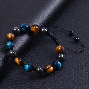 Macro detail of 10mm blue and brown tiger eye stone beads on braided cord bracelet