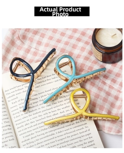 Detailed set of three colorful metal shark hair claws on a vintage book background