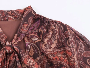 Detail of bohemian chiffon neck tie with paisley pattern and pleated shoulder design