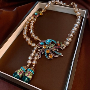 Detail of vintage flower necklace with champagne beads and colorful rhinestones in a box