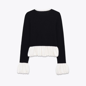 Elegant black knit long sleeve top with white ruffled hem and contrasting trim details