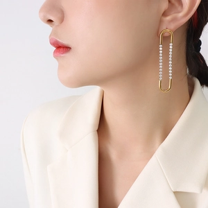 French U-shaped gold earrings with cubic zirconia inlay on elegant model pose