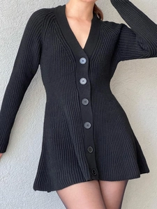 Détail d'une robe cardigan noire en maille avec col en V, manches longues et boutons