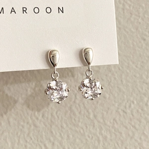 Macro detail of square-cut zircon drop earrings in 925 sterling silver with claw setting