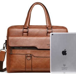 Vintage brown leather briefcase with top handles and shoulder strap next to an iPad