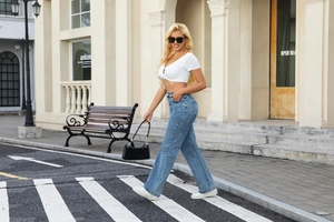 Straßenansicht der hellblauen High-Waist-Jeans mit weitem Bein und weißem kurzem Top