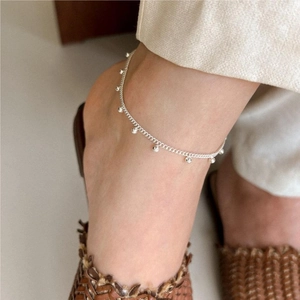 Close-up of minimalist S925 sterling silver beaded anklet on a woman's ankle