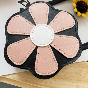 Detail view of flower-shaped kids PU leather bag with pink petals and white stitching