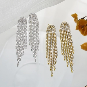 Detailed view of gold and silver rhinestone tassel drop earrings on white background