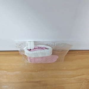 Detailed view of a pink knitted Christmas mini sock in its protective plastic packaging
