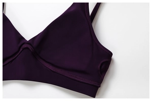 Detailed close-up of stitching and matte texture on a deep purple sports bra