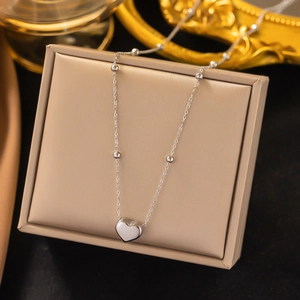 Silver titanium steel heart necklace with bead chain on a beige jewelry display box