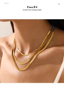 Close-up of three layered gold herringbone flat snake chains on a woman's neck