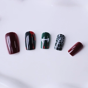 Halloween press-on nails with blood drips, spider webs, and vampire fang designs on white