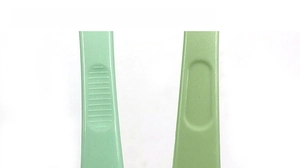 Detail of green plastic shoe brush handle showing anti-slip texture and grip grooves