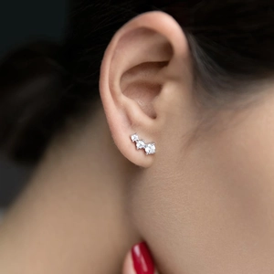 Close-up of S925 sterling silver ear cuff set with three sparkling round zircons on model