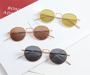 Detailed view of three vintage round metal sunglasses in yellow, brown, and grey lenses