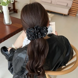 Floral print hair scrunchie in black and yellow styling a ponytail hairstyle