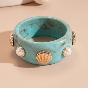 Macro shot of turquoise marble resin bangle with gold seashell and pearl accents