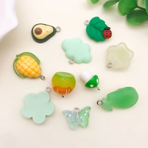 Flache Darstellung grüner Harz-DIY-Anhänger mit Avocado-, Schmetterlings- und Pilzformen
