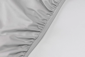 Détail du tissu texturé gris clair présentant un bord froncé élastique à haute élasticité