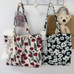 Detail of floral canvas tote bags with delicate white lace bow accents on straps